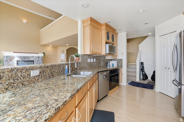 2887 View Crest Circle North Logan, UT 84341 - Photo 9 of 37 Kitchen with light stone countertops, light wood finish cabinets, tasteful backsplash, stainless steel appliances, and arched walkways