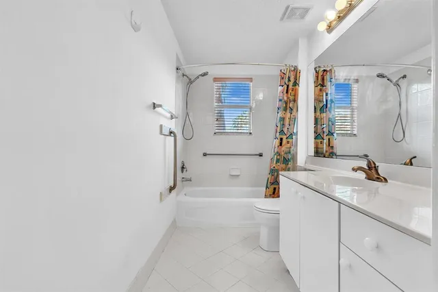 a front view of a house with a garden and trees