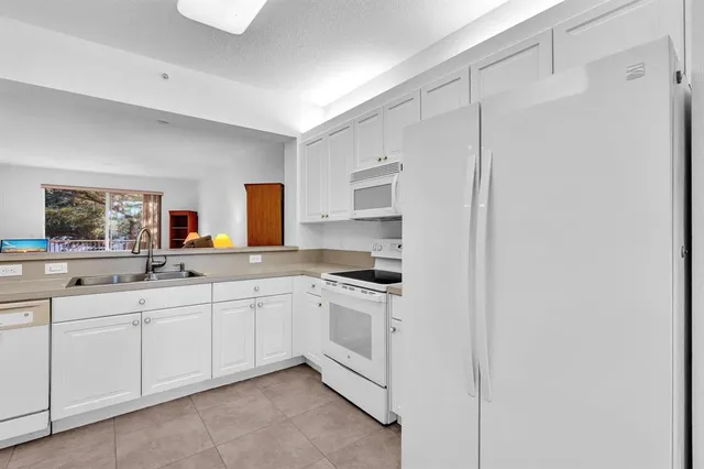 a kitchen with stainless steel appliances white cabinets and wooden floor