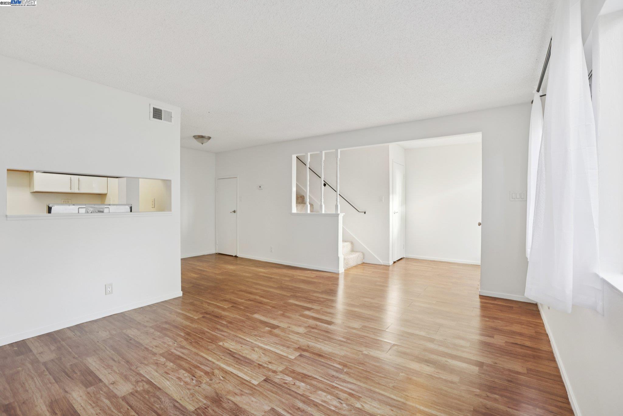 a view of empty room with wooden floor