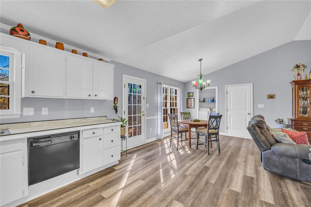 375 Brookstone Drive Athens, GA 30605 - Photo 18 of 70 a kitchen with granite countertop a dining table chairs stove and white cabinets