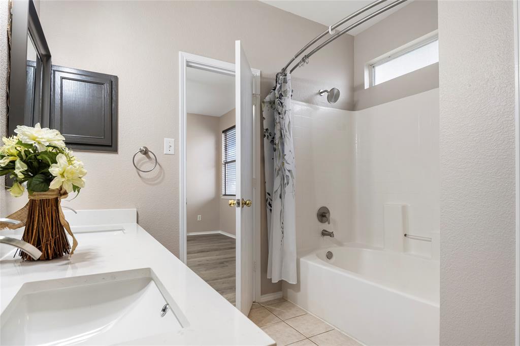 7900 Hidden Path Lane Denton, TX 76210 - Photo 16 of 25 a bathroom with a tub sink and mirror