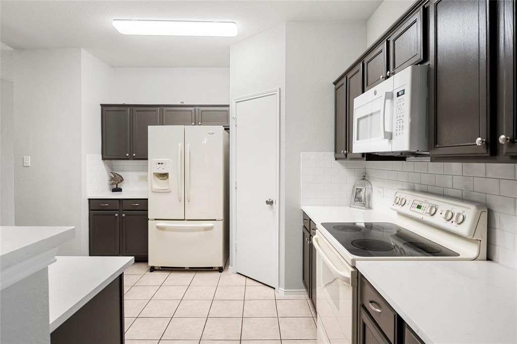 7900 Hidden Path Lane Denton, TX 76210 - Photo 5 of 25 a kitchen with a refrigerator sink and white cabinets
