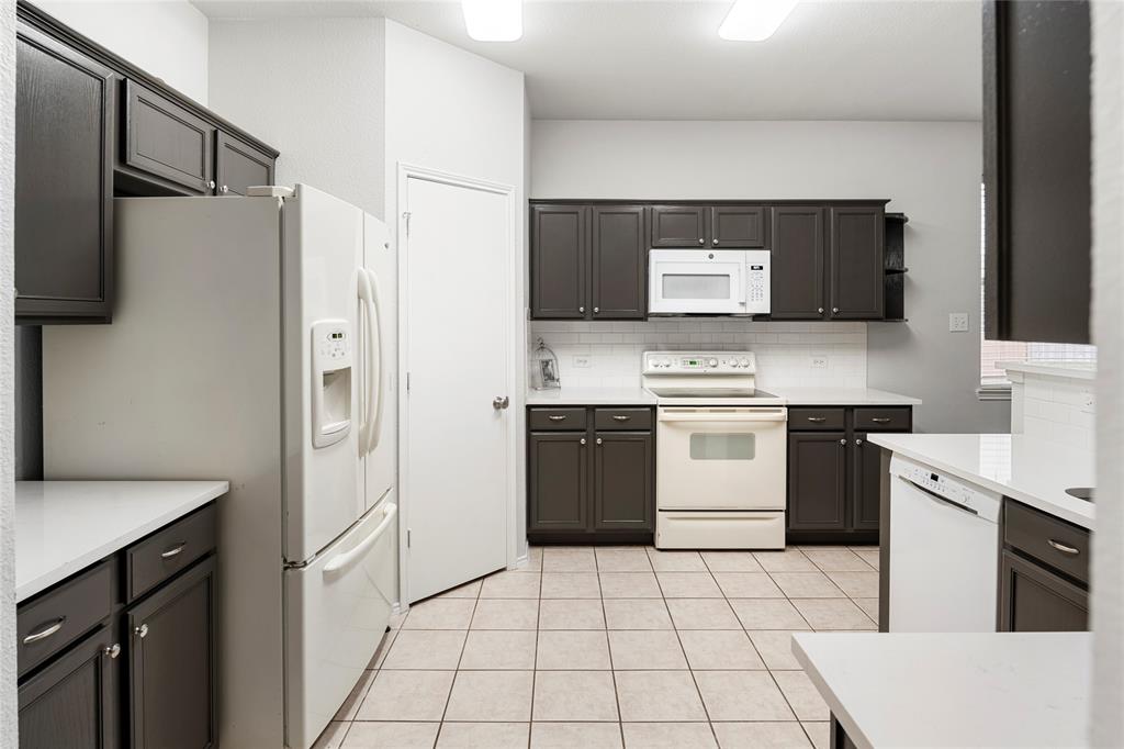 7900 Hidden Path Lane Denton, TX 76210 - Photo 7 of 25 a kitchen with a stove a refrigerator and a sink