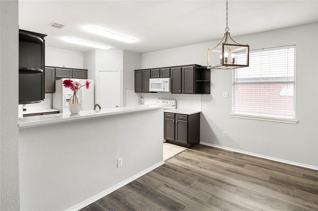 7900 Hidden Path Lane Denton, TX 76210 - Photo 8 of 25 a kitchen with stainless steel appliances a microwave and a refrigerator