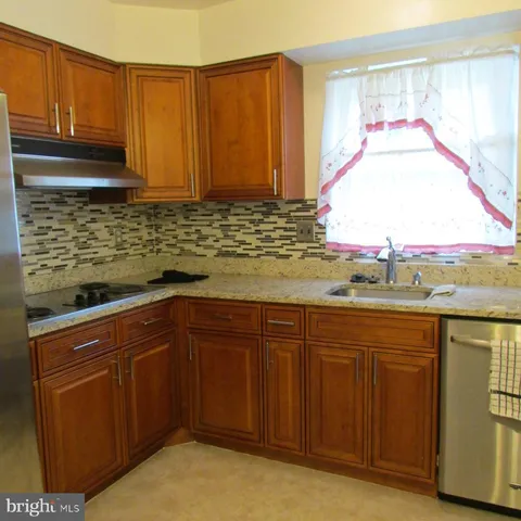 a kitchen with stainless steel appliances granite countertop wooden cabinets a sink and dishwasher