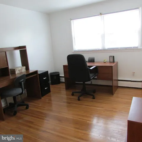 a view of a workspace with furniture and a window