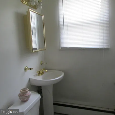 a bathroom with a sink a window and a toilet