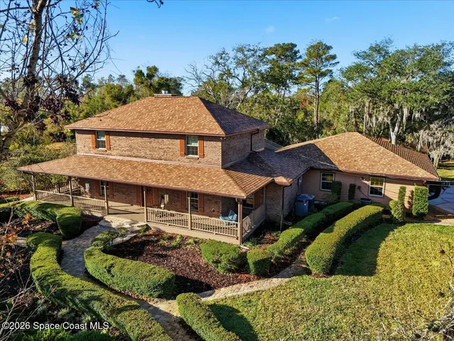 a aerial view of a house with a yard table and chairs