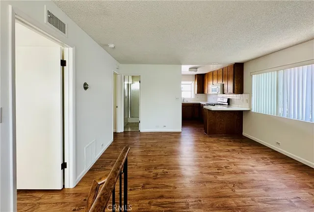 a view of a kitchen with wooden floor and a window