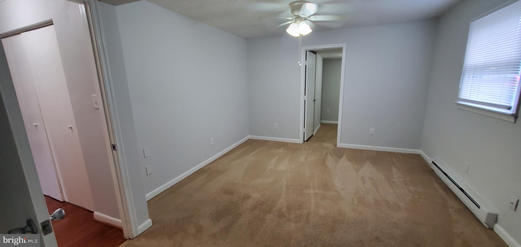 816 North Commerce Avenue, Unit B Front Royal, VA 22630 - Photo 10 of 12 an empty room with a chandelier fan and a window