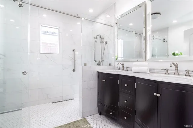a bathroom with a double vanity sink mirror and shower