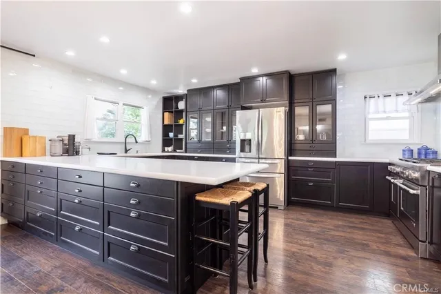 a kitchen with stainless steel appliances granite countertop sink cabinets and wooden floor