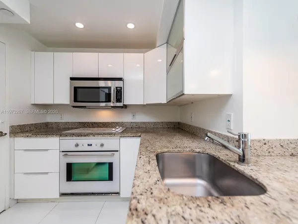 a living room with furniture a flat screen tv and a floor to ceiling window