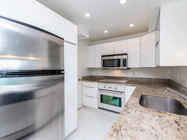 a kitchen with granite countertop a sink and a stove top oven with granite countertops
