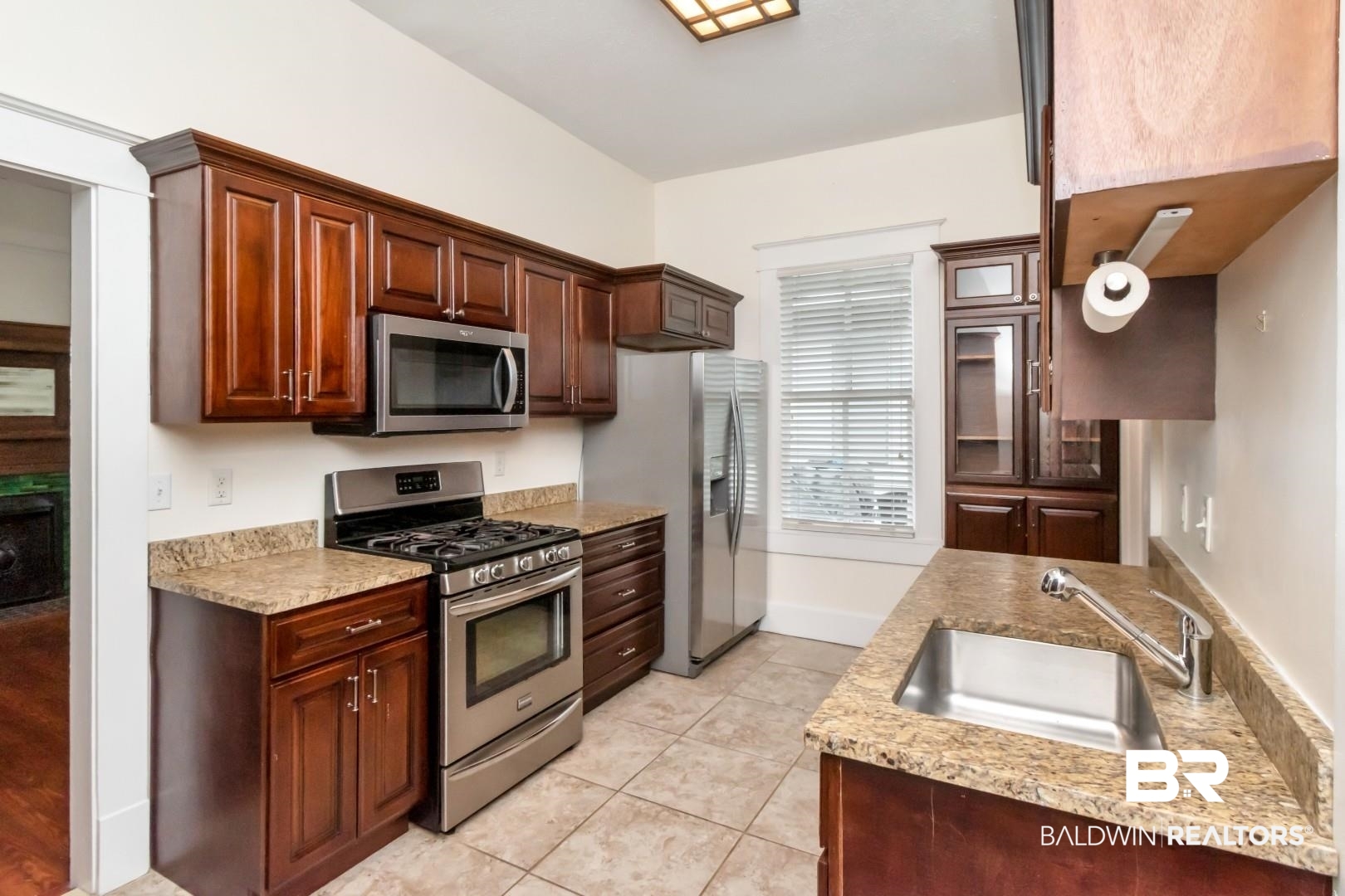 14 Kenneth Street Mobile, AL 36607 - Photo 10 of 32 Kitchen with stainless steel appliances, light stone countertops, and light tile patterned floors