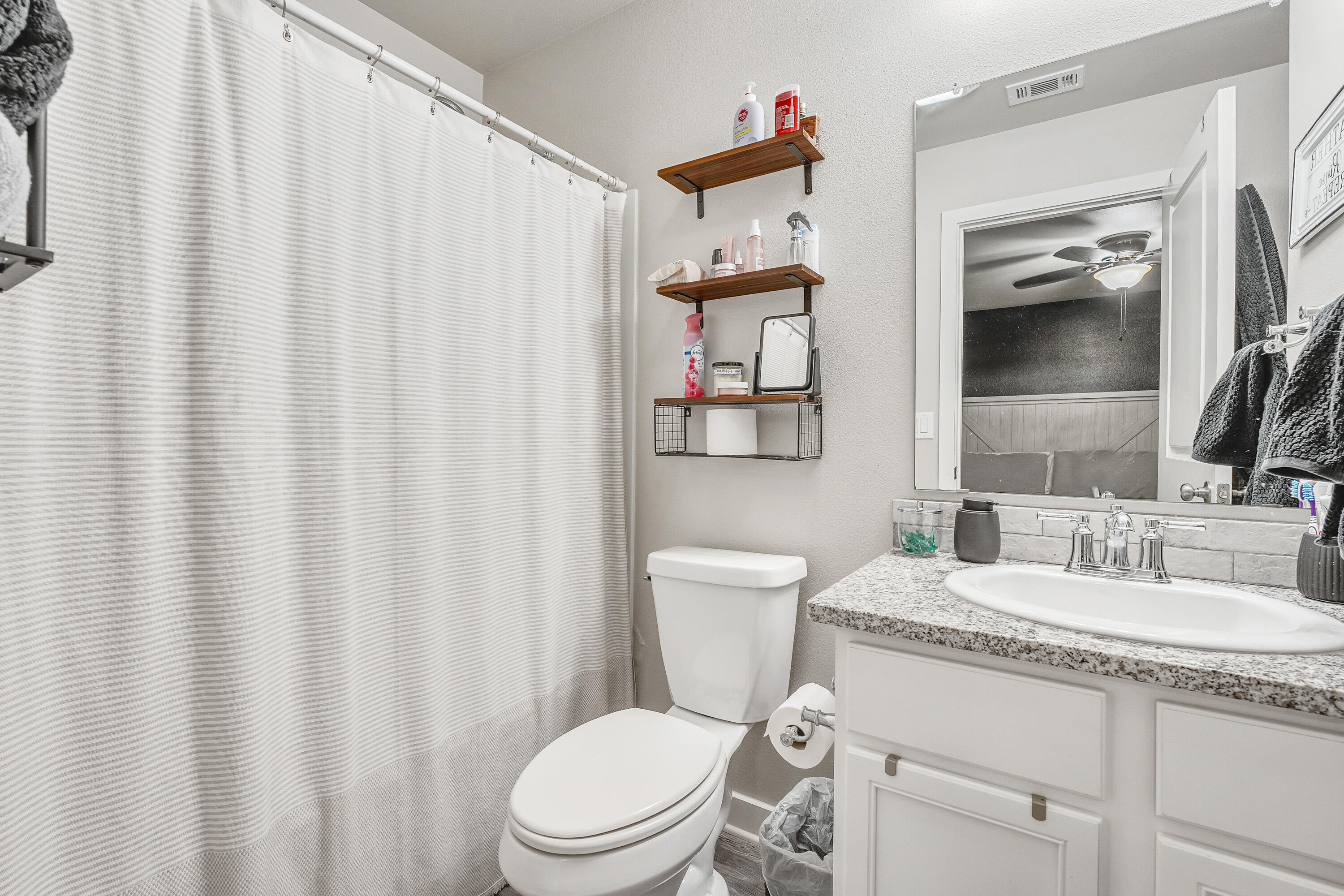 7510 28th Street Lubbock, TX 79407 - Photo 11 of 19 a bathroom with a toilet a sink and curtain