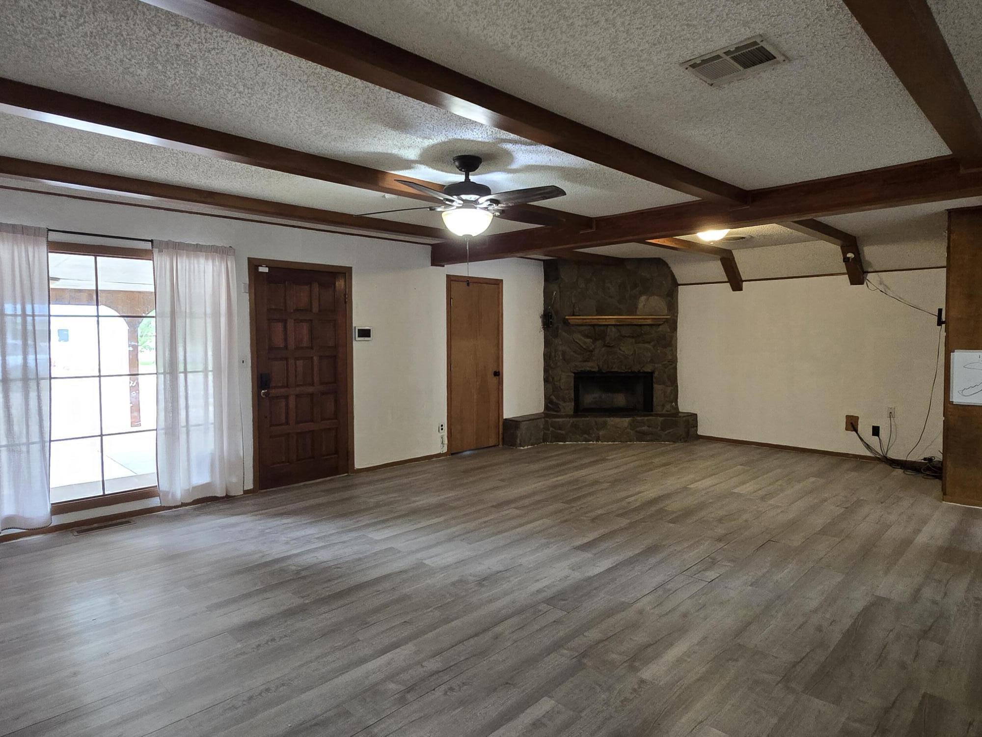 506 North 19th Street Lamesa, TX 79331 - Photo 3 of 29 a view of a livingroom with a fireplace a ceiling fan and window