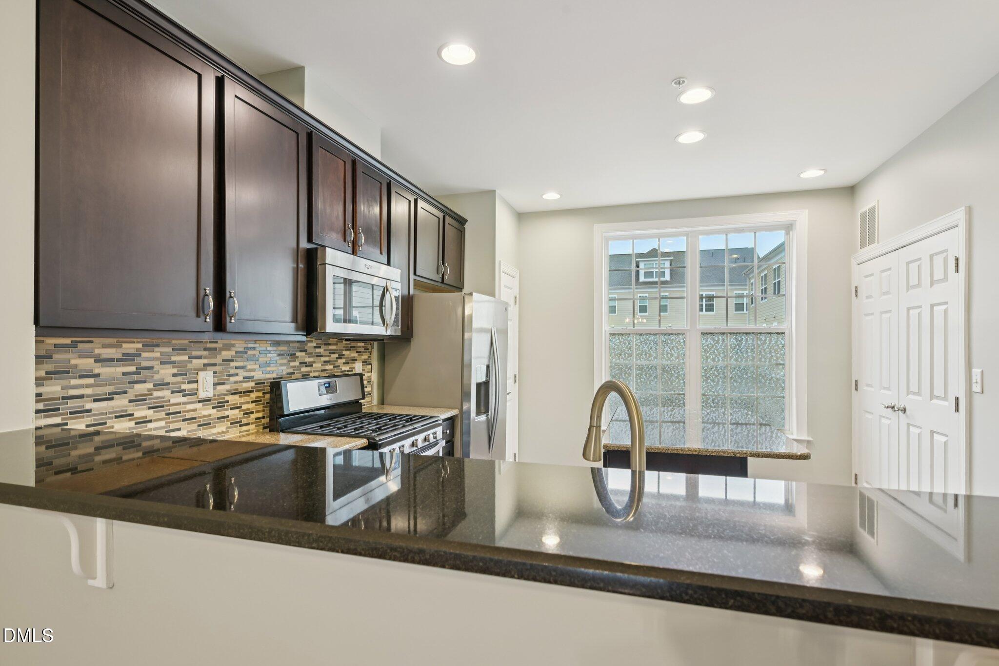 10510 Sablewood Drive, Unit 113 Raleigh, NC 27617 - Photo 12 of 38 a kitchen with stainless steel appliances granite countertop a sink and a microwave