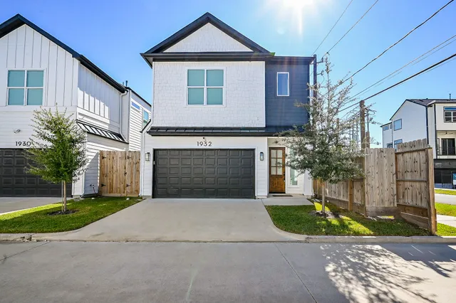 a front view of a house with a garden and garage