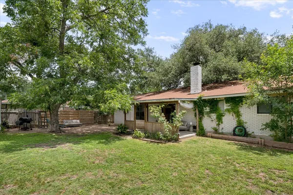 a view of a house with backyard garden and sitting area