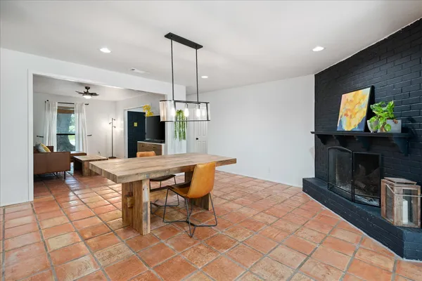a dining hall with a dining table chairs and a fire place