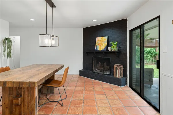 a outdoor kitchen with stainless steel appliances granite countertop a stove a refrigerator a oven a sink with a dining table and chairs