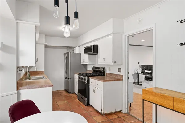 a kitchen with stainless steel appliances granite countertop a sink and a refrigerator
