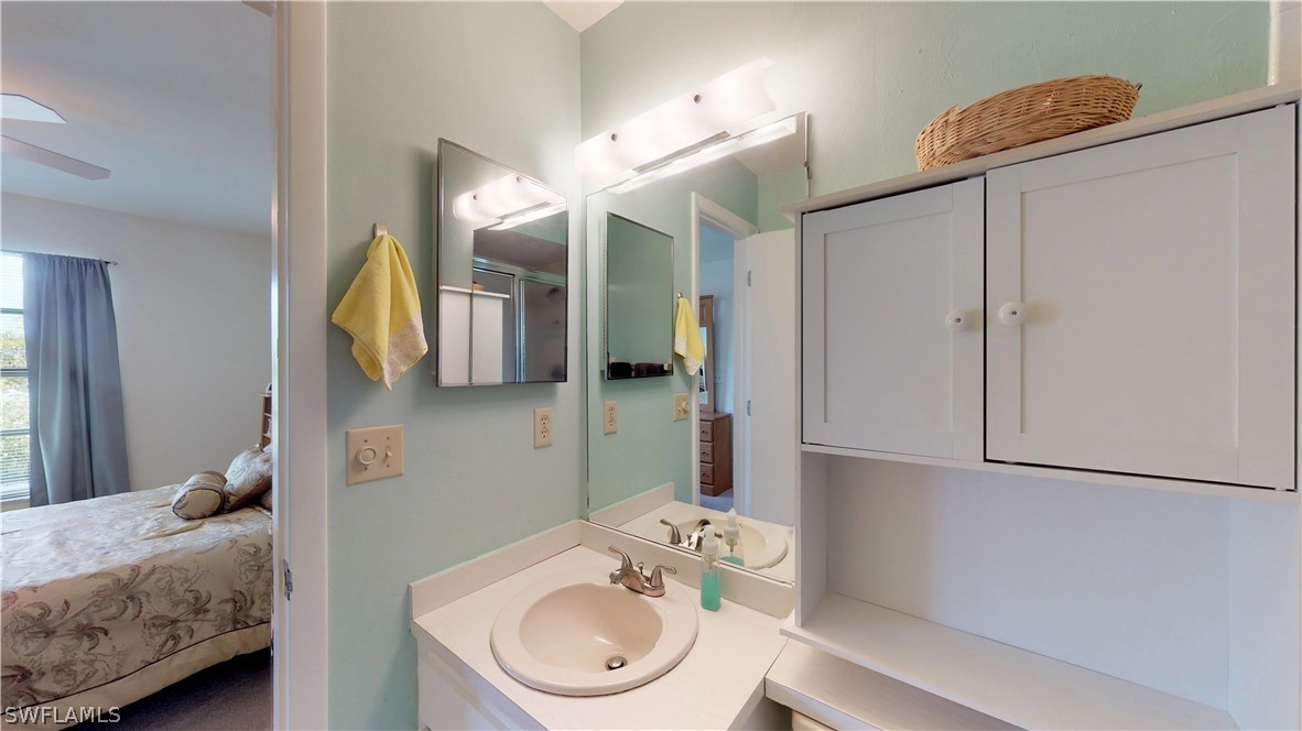 1100 Pondella Road, Unit 811 Cape Coral, FL 33909 - Photo 14 of 35 a en suite bathroom with a granite countertop sink and a mirror