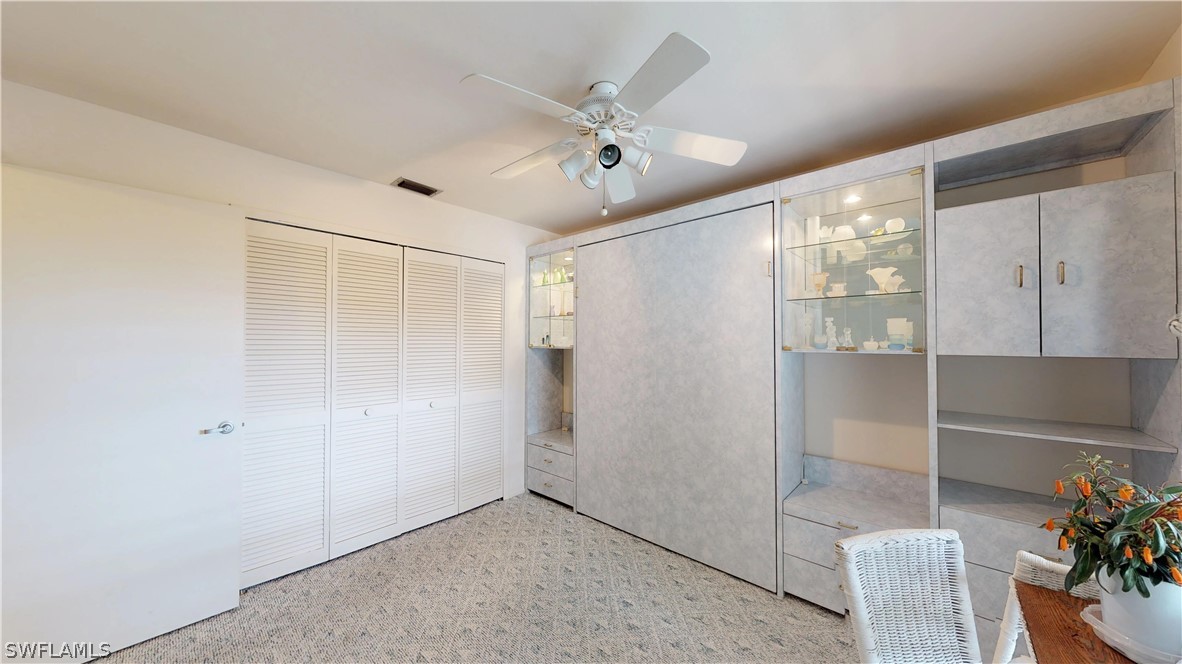 1100 Pondella Road, Unit 811 Cape Coral, FL 33909 - Photo 16 of 35 a view of an empty room with a chandelier fan and wooden floor