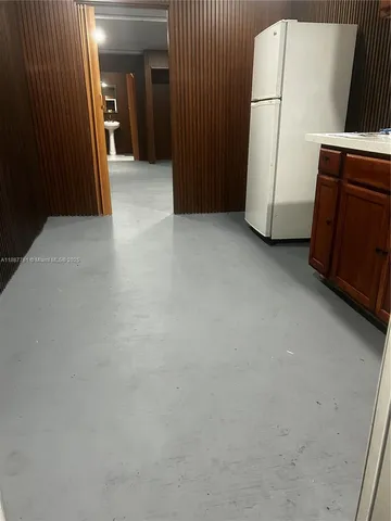 a view of a storage and utility room with a refrigerator