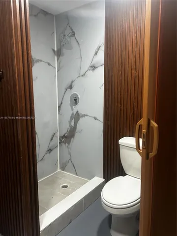 a bathroom with a toilet and a shower