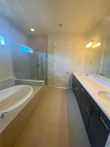 a bathroom with a bathtub and double sink