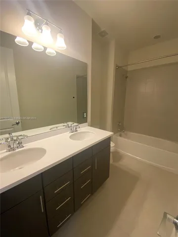 a bathroom with a bathtub sink vanity and mirror