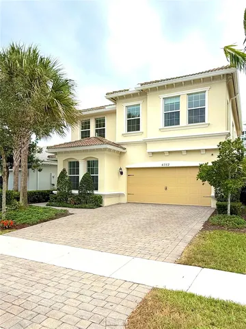 a front view of a house with a yard and potted plants