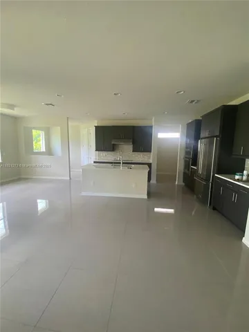 a view of a kitchen with a sink and a refrigerator