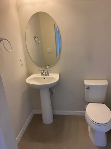 a bathroom with a sink toilet and a mirror