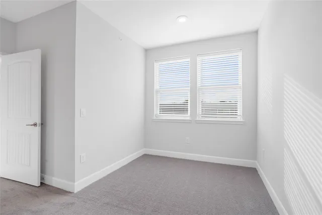 an empty room with a window and a ceiling fan