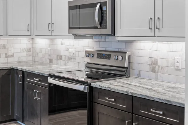 a kitchen with a sink a stove a refrigerator and cabinets