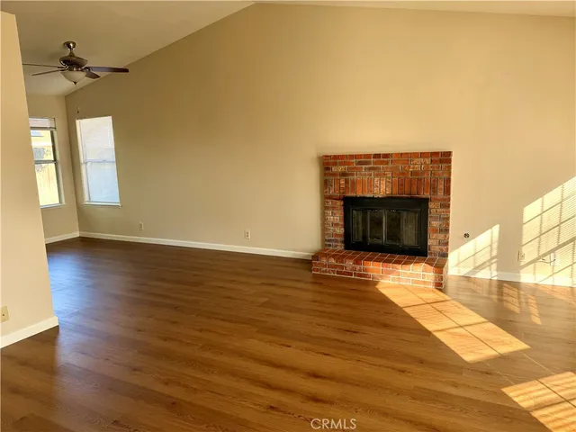 a view of empty room with wooden floor and fireplace