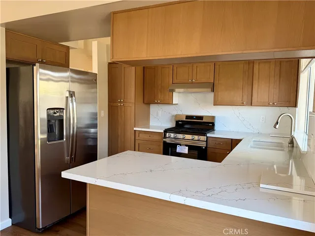 a kitchen with stainless steel appliances a refrigerator and a stove