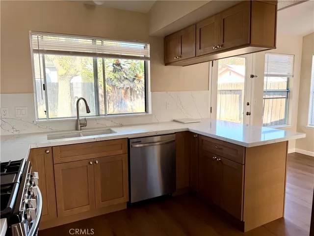 a kitchen with granite countertop a sink window and cabinets
