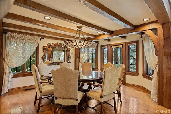 a dining room with furniture a chandelier and wooden floor