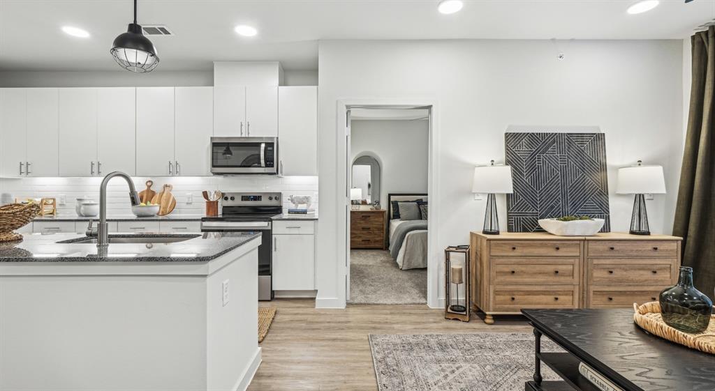 4600 East McKinney Street, Unit 5317 Denton, TX 76208 - Photo 31 of 40 a kitchen with a stove a sink and a refrigerator