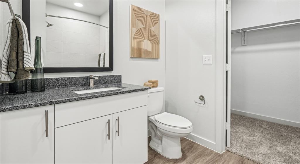4600 East McKinney Street, Unit 5317 Denton, TX 76208 - Photo 35 of 40 a bathroom with a granite countertop sink a toilet and a mirror