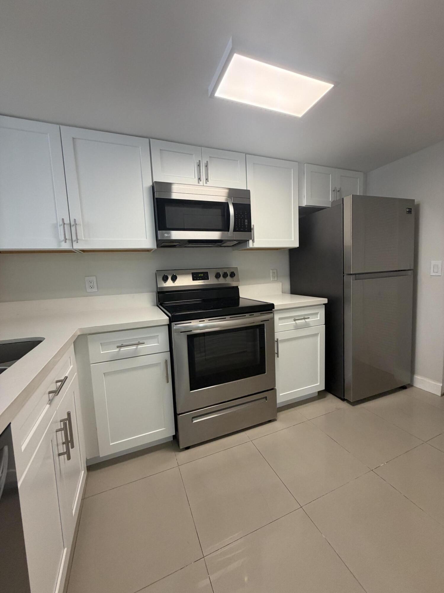 5031 Wiles Road, Unit 203 Coconut Creek, FL 33073 - Photo 11 of 24 a kitchen with cabinets stainless steel appliances and sink