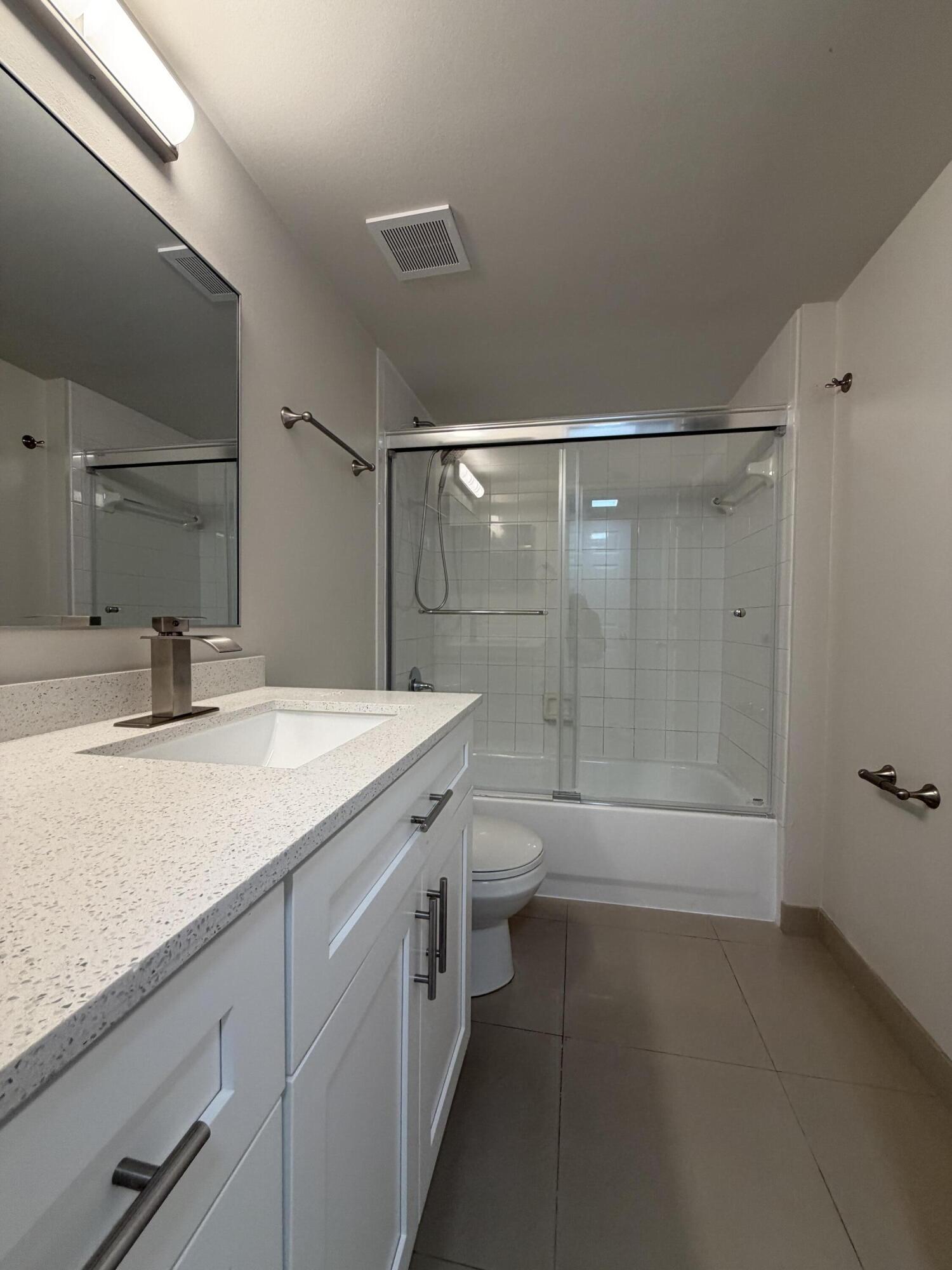 5031 Wiles Road, Unit 203 Coconut Creek, FL 33073 - Photo 23 of 24 a bathroom with a sink a toilet and shower