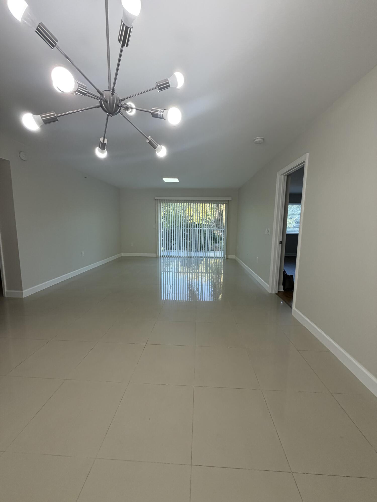 5031 Wiles Road, Unit 203 Coconut Creek, FL 33073 - Photo 3 of 24 an empty room with a ceiling fan and window