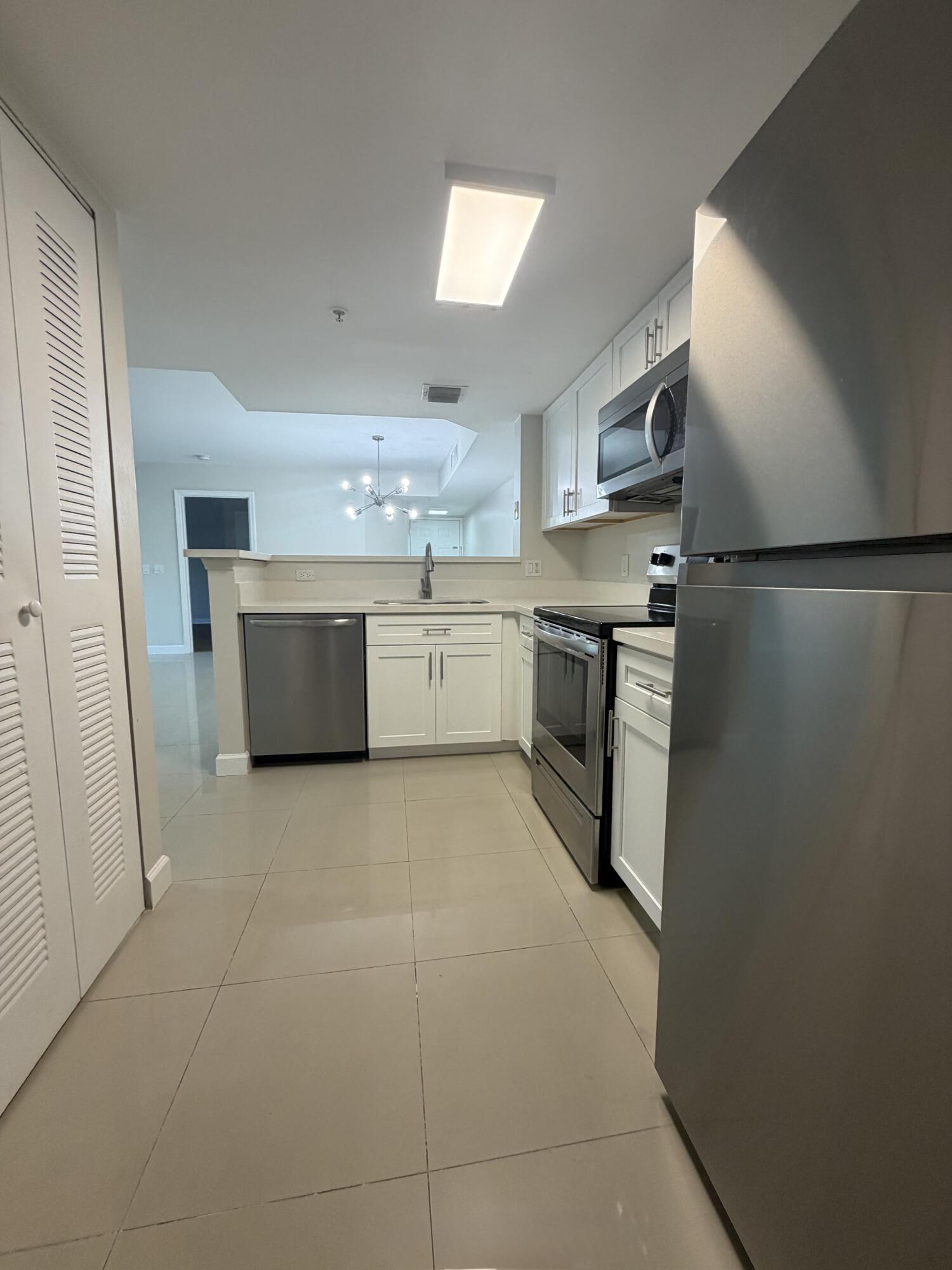 5031 Wiles Road, Unit 203 Coconut Creek, FL 33073 - Photo 10 of 24 a large kitchen with cabinets and stainless steel appliances