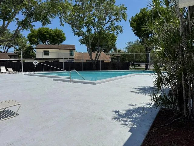 a view of a pool with a yard and plants
